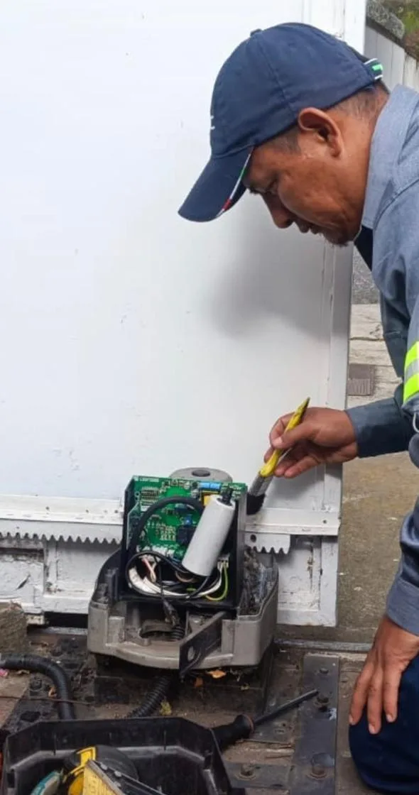 Técnico revisando la tarjeta del motor de un portón eléctrico